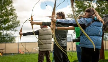 Group of people taking place in an archery team building activity