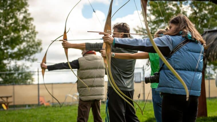 Group of people taking place in an archery team building activity