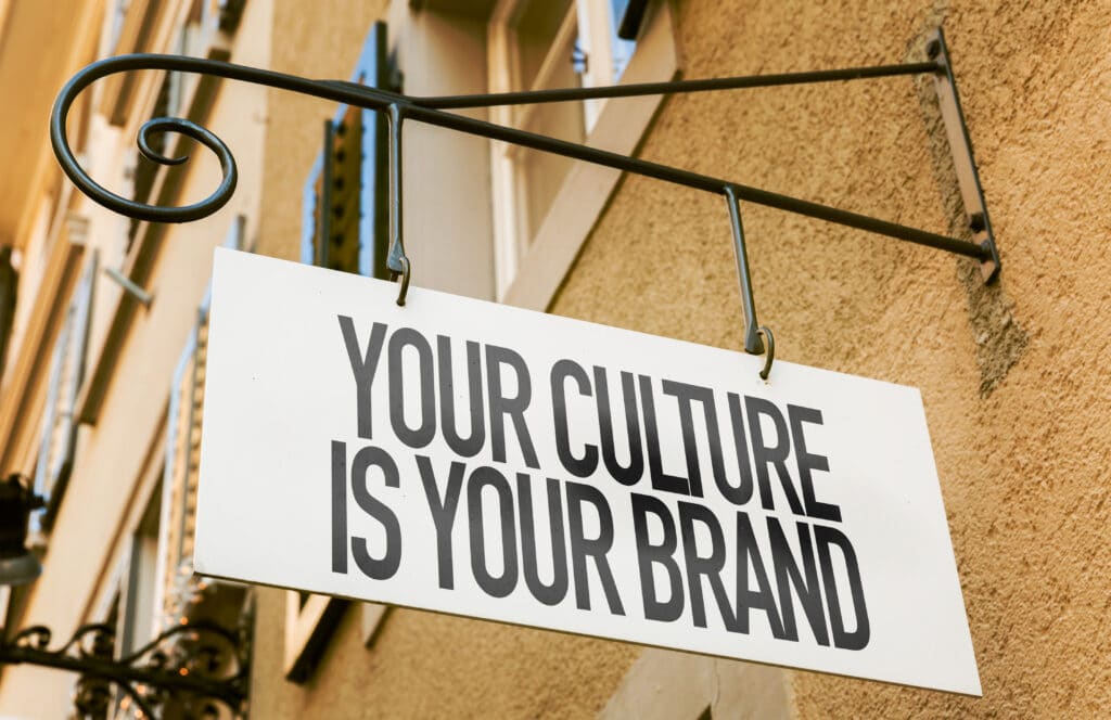 Sign hanging outside a shop saying "Your culture is your brand" - Developing a new team