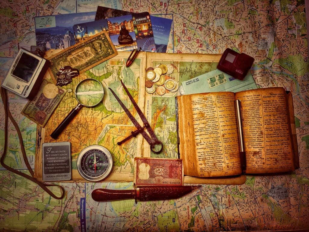 An old map with lots of treasure hunt items on top of it such as a compass money, clues, etc.